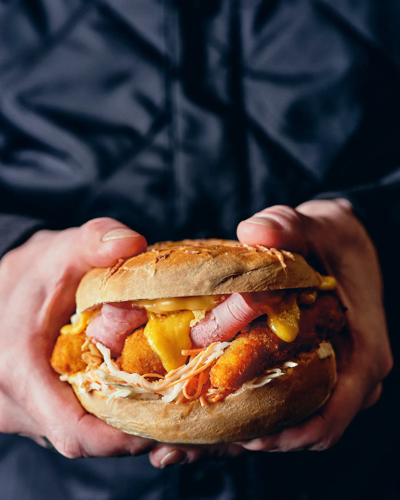 Un bagel garni tenu à deux mains