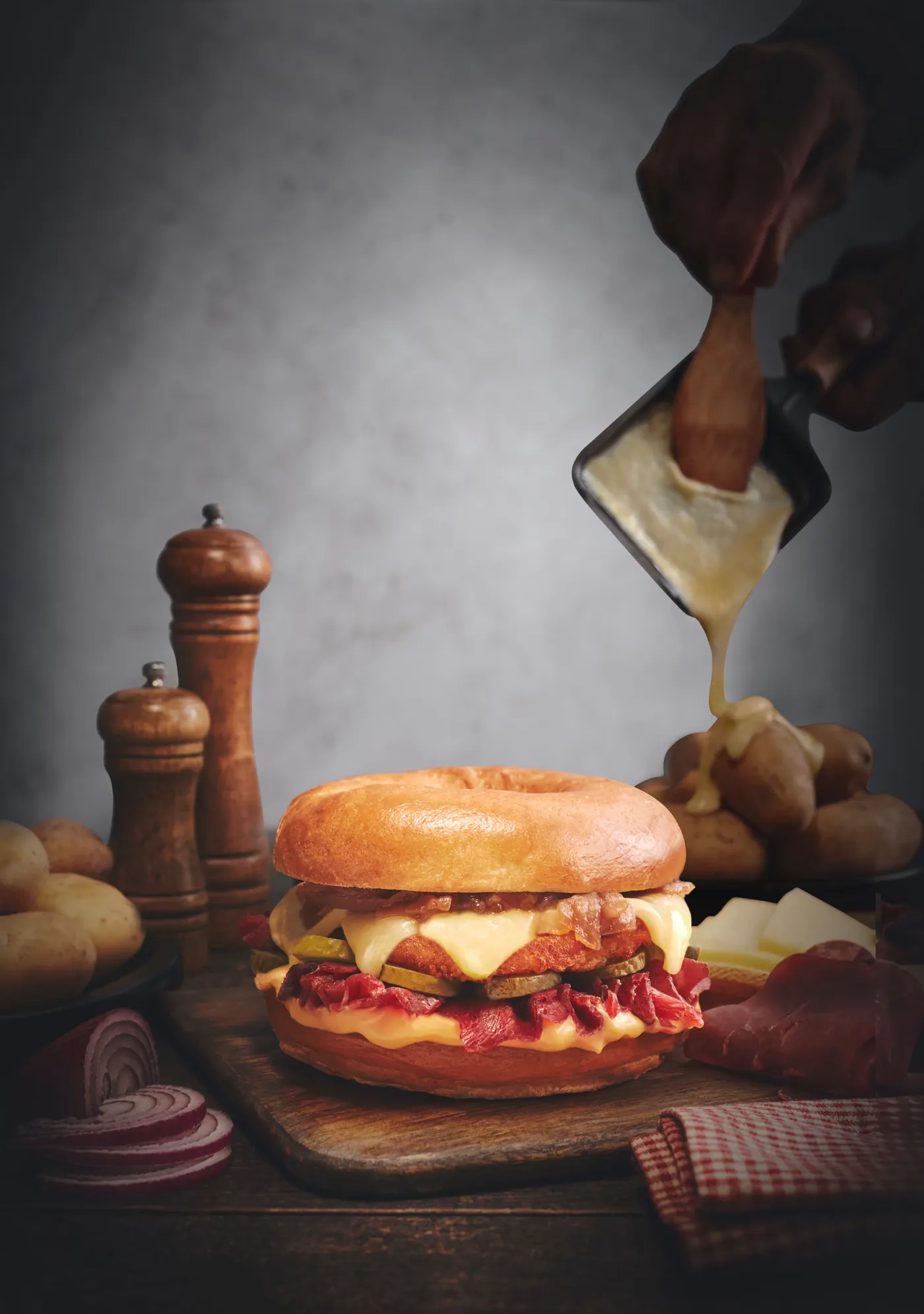 Fromage à raclette coulé sur un bagel pastrami et cornichons