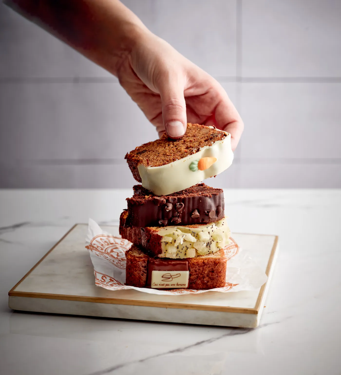 Trois tranches de cakes empilées, la main en attrape une