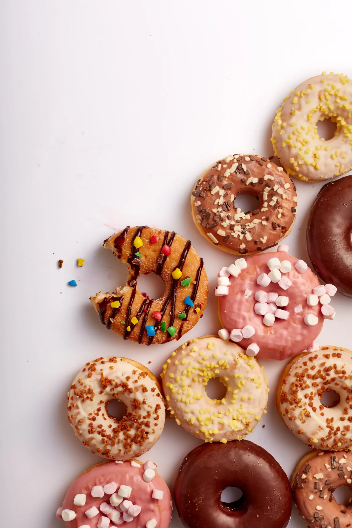 Donuts glacés assortis disposés sur fond blanc
