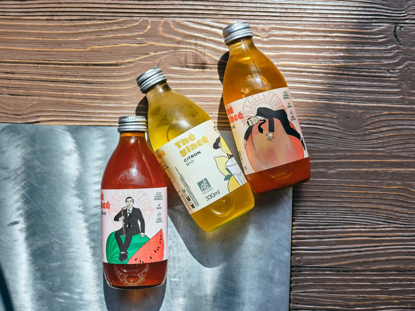Trois limonades artisanales en bouteille sur une table en bois