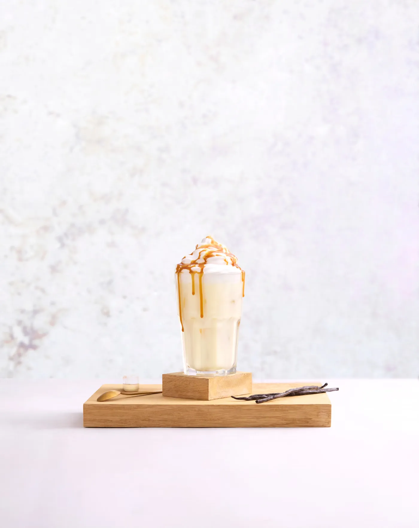 Milkshake vanille nappé de caramel sur une planche en bois
